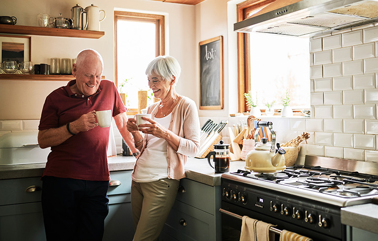 elderly couple drinking coffee in the kitchen