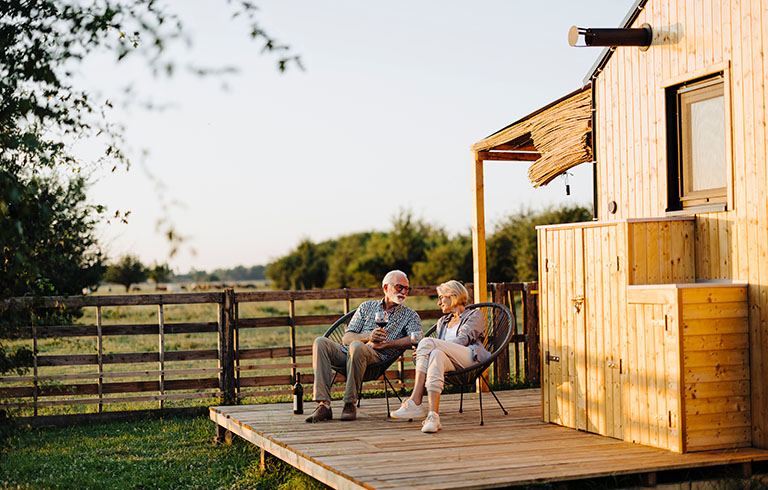 elderly couple sitting on the patio of their home