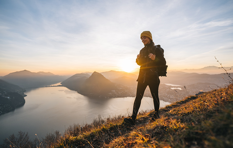 woman standing on a mountain with lake scenery