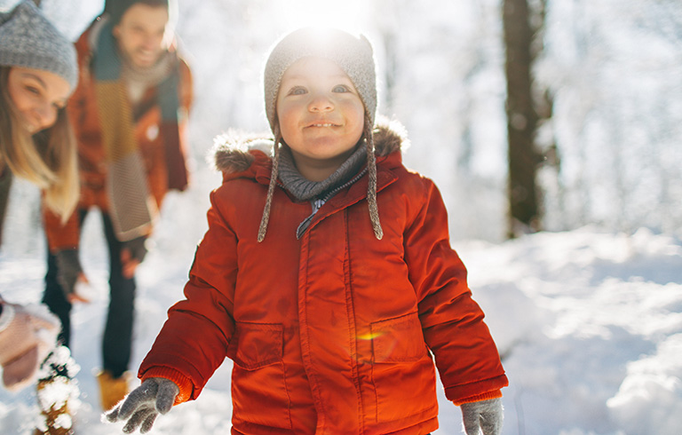 kid in the snow with his parents