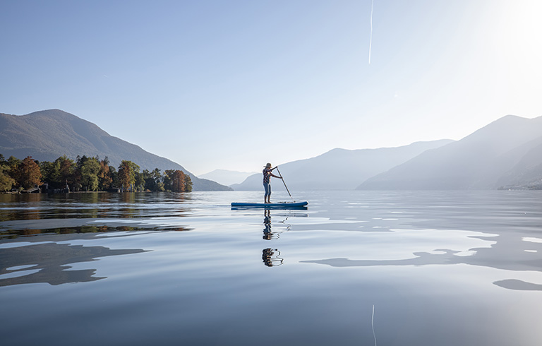 person paddleboarding on a lake in the mountains