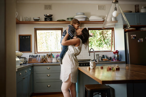 Mother holding a toddler in kitchen