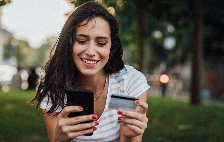 teen girl looking at her phone and card