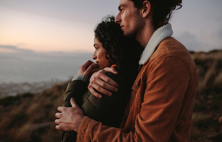 young couple hugging outside