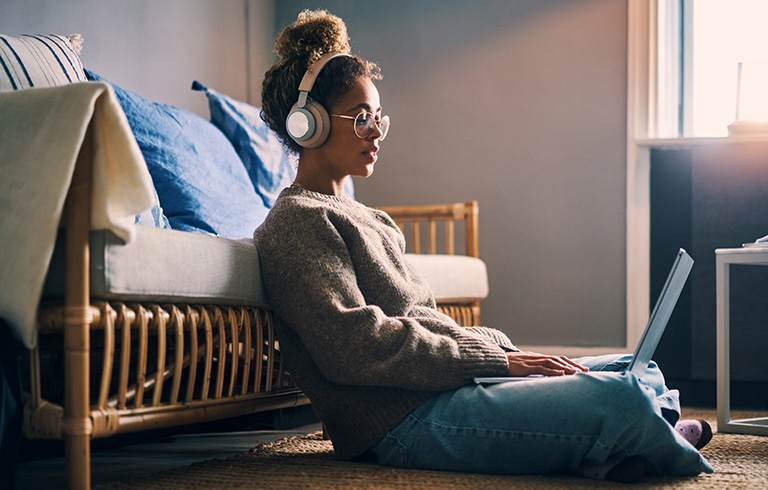 young woman sitting on the floor using her laptop