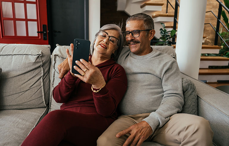 Couple on a sofa looking at a phone
