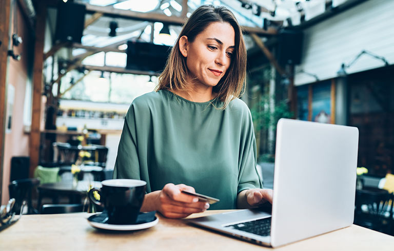 Woman using a credit card with her laptop