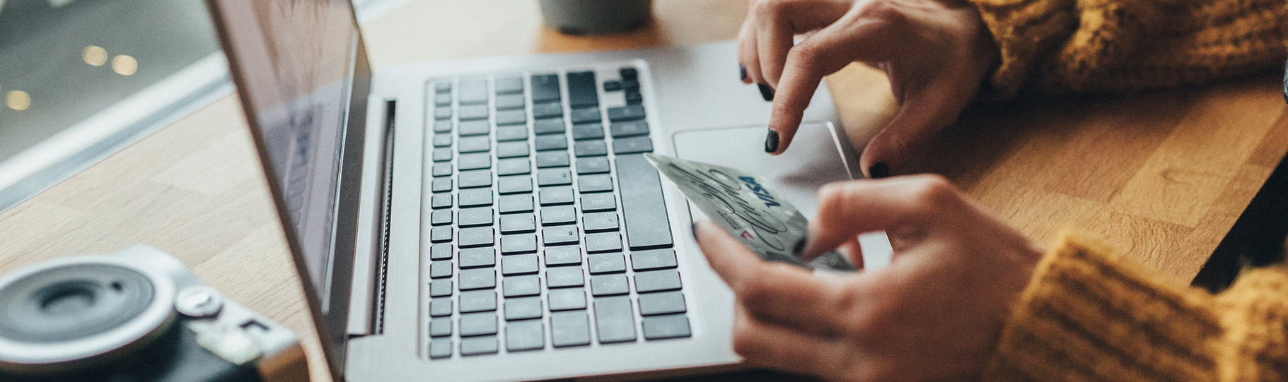 person making an online purchase on their laptop with a mountain america visa card