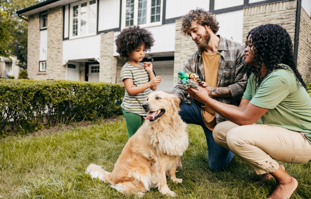 happy family outside the house with their golden retriever dog