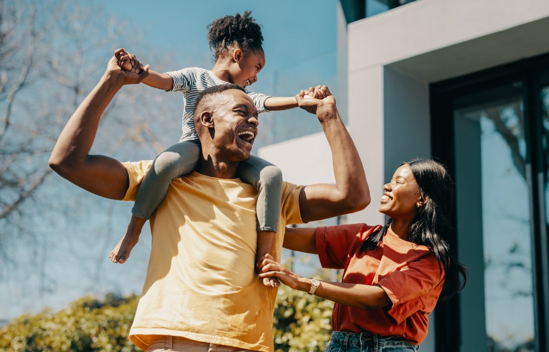 parents outside with the daughter on her dad's shoulders