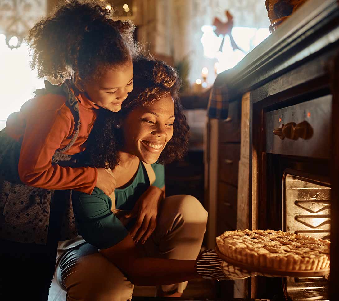 Mother and daughter baking a pie