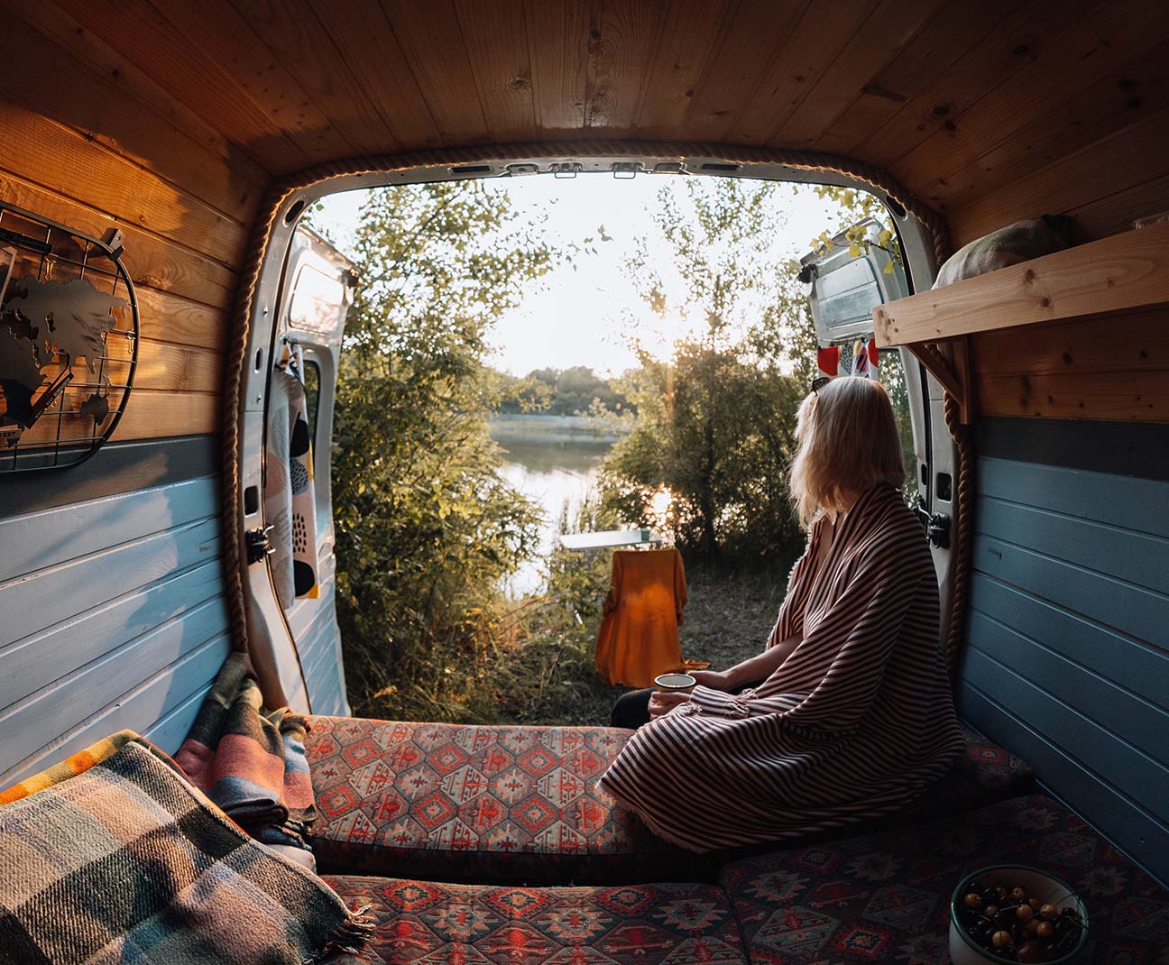 woman sitting in her van looking out the back