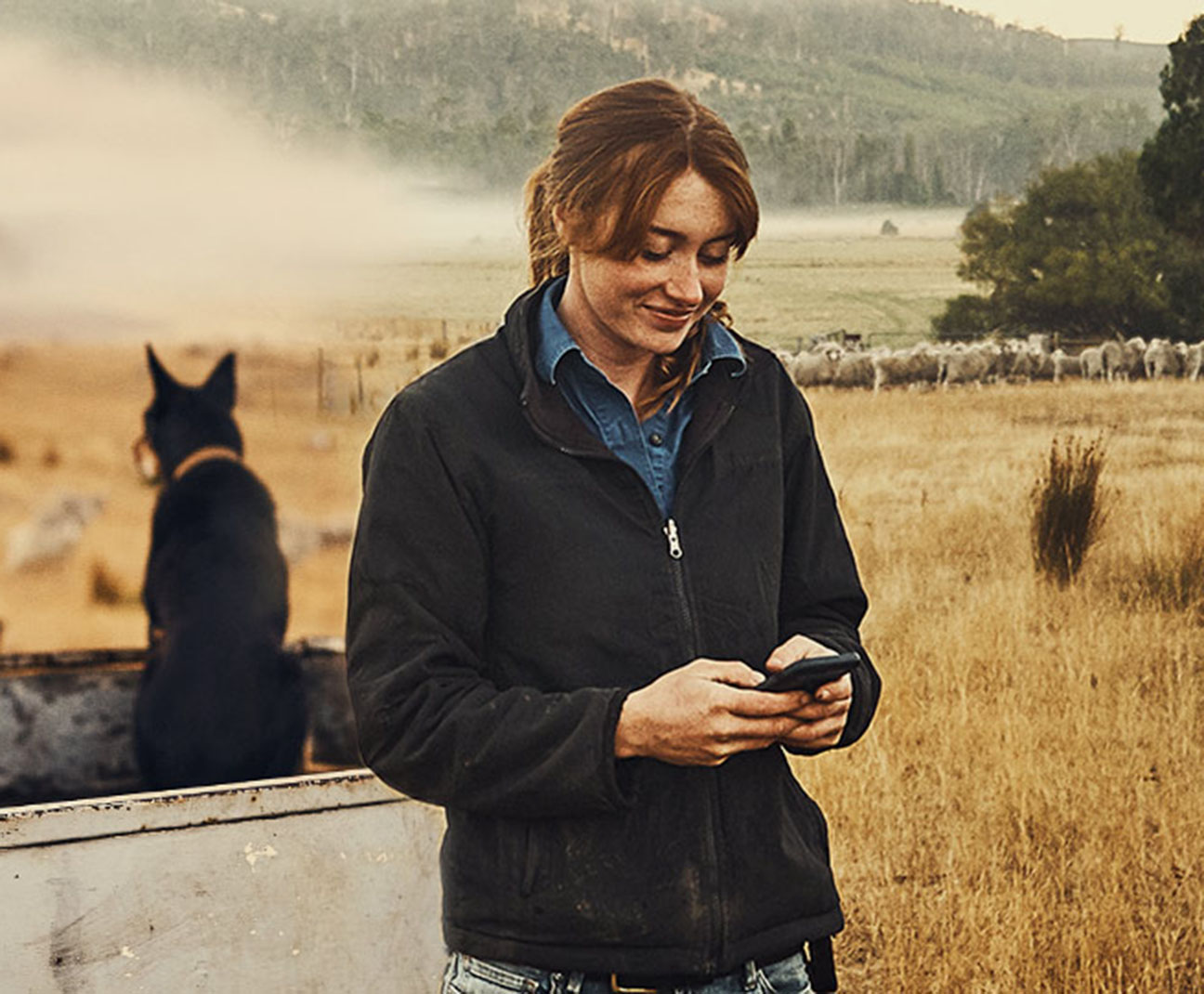 woman on her phone on a farm