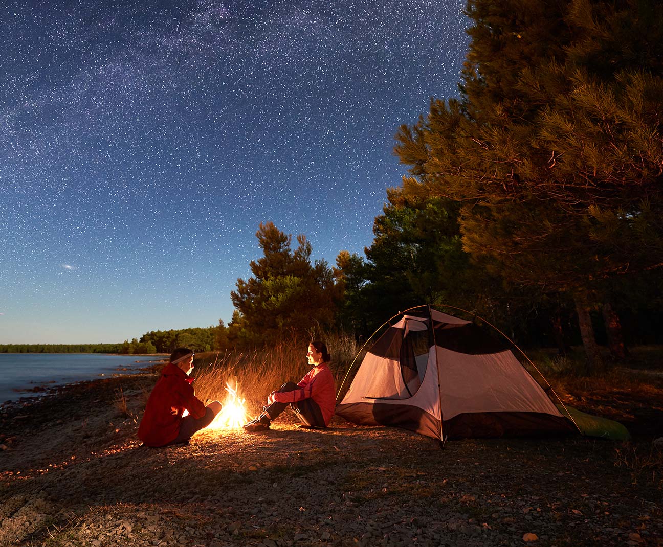 two people around a fire on their camp site