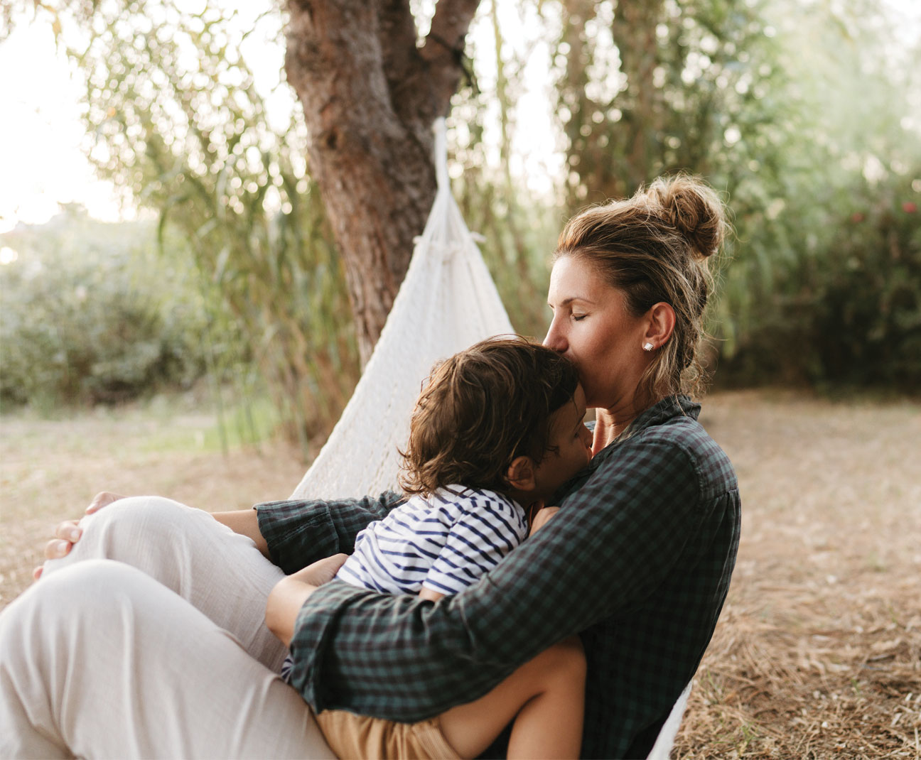 Mother holding a toddler in a hammock