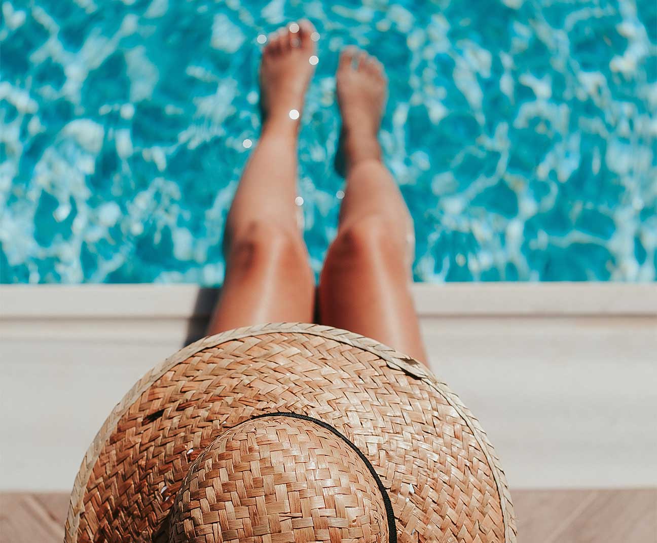 Woman relaxing with feet in a pool