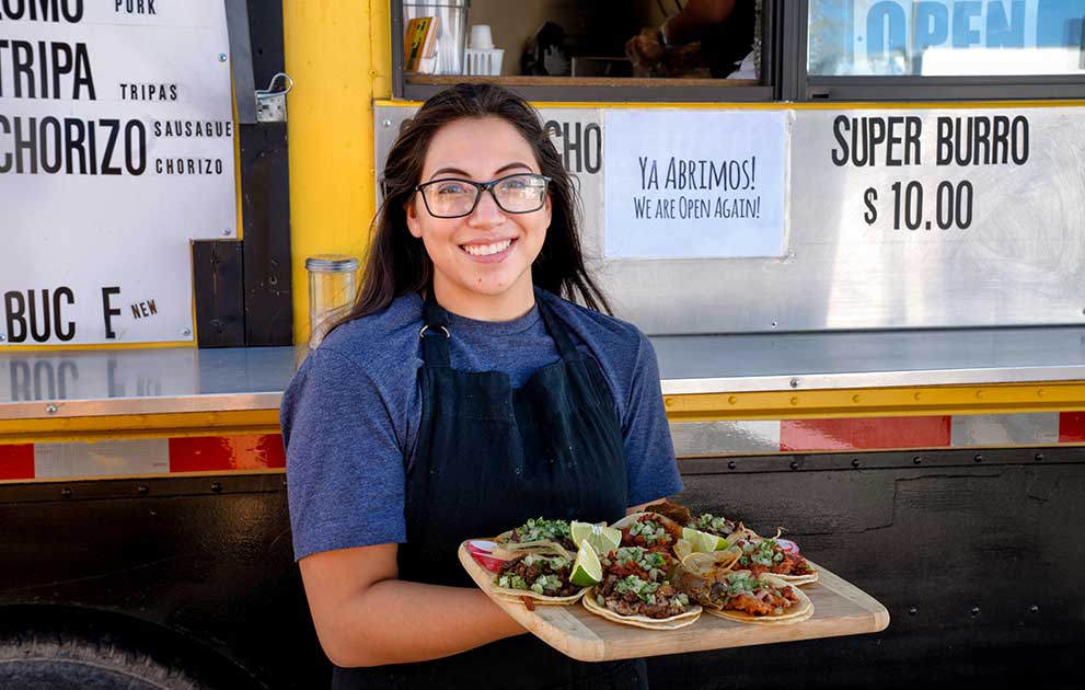 Young woman serving tacos