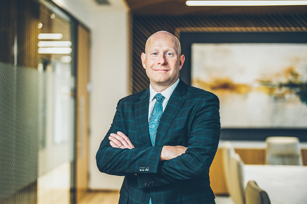 nathan anderson in blue suit with arms folded