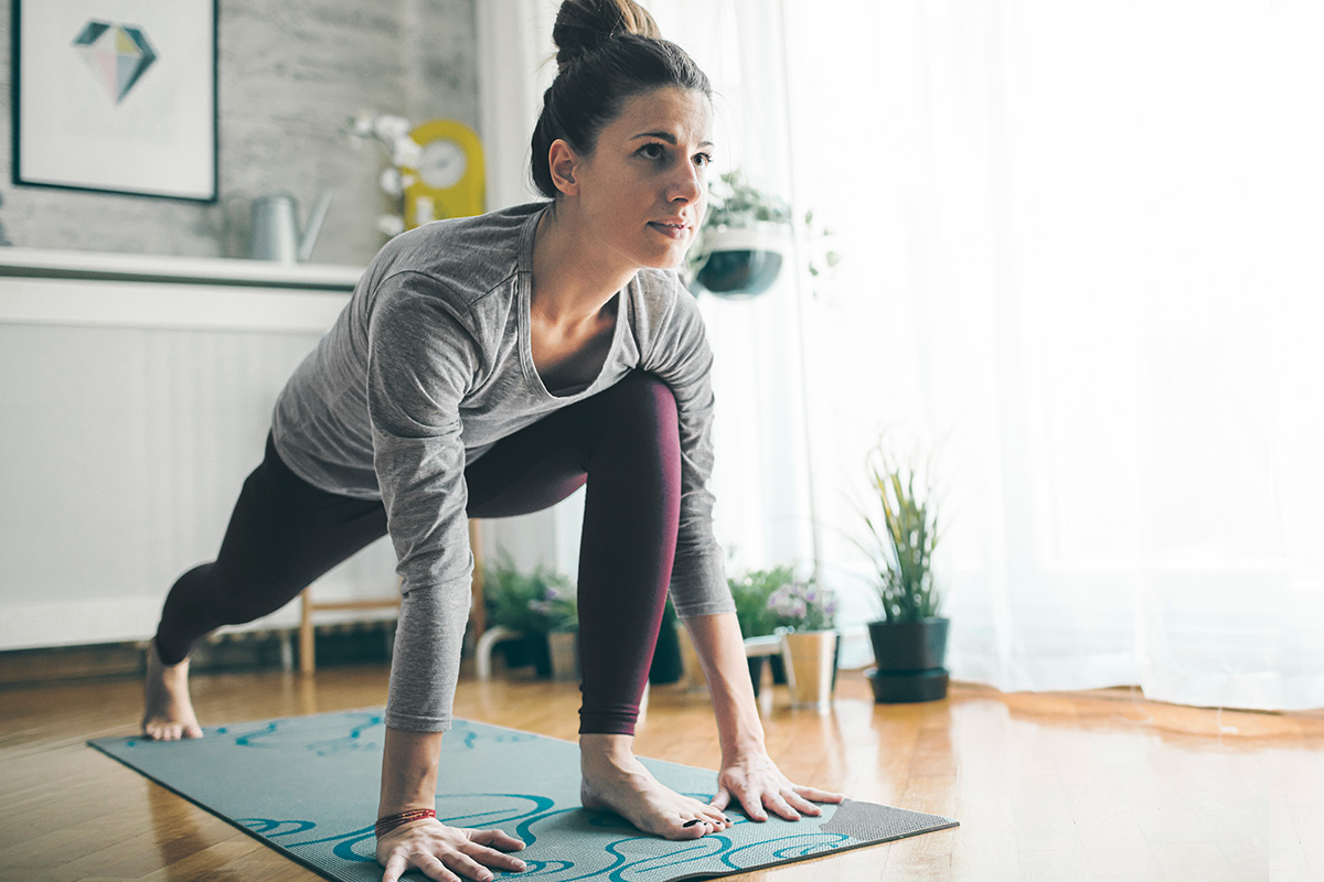 Woman on a yoga mat doing a yoga pose