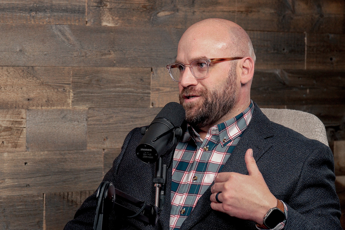 man with glasses at podcast microphone