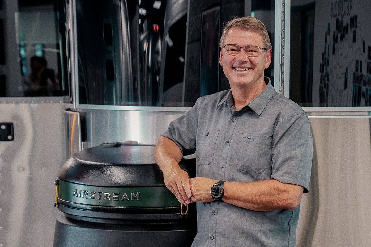 man in glasses in front of airstream trailer