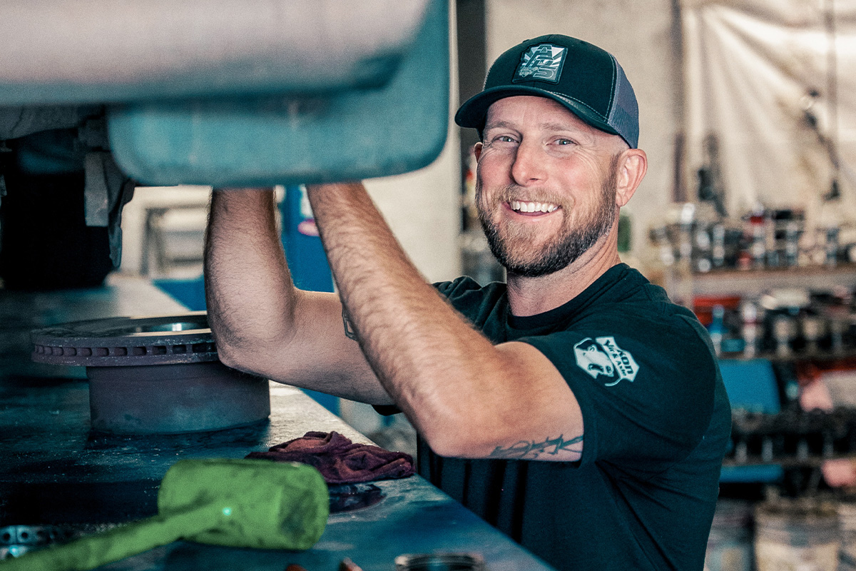 bearded man smiling working on car