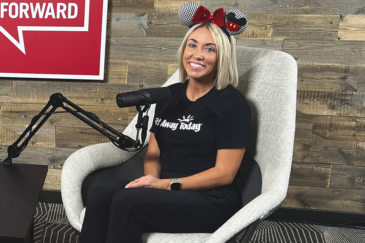 blonde woman with red, black and white Mickey ears at the podcast mic
