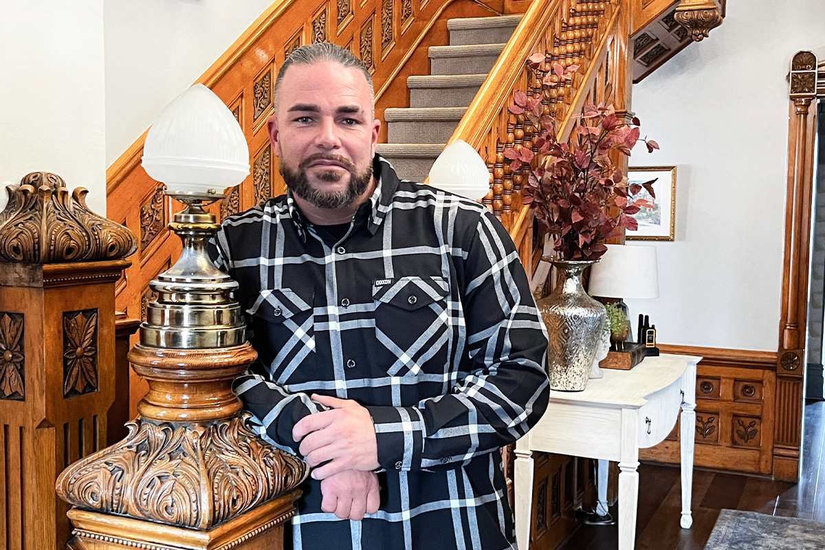 collin cooper standing at bottom of staircase