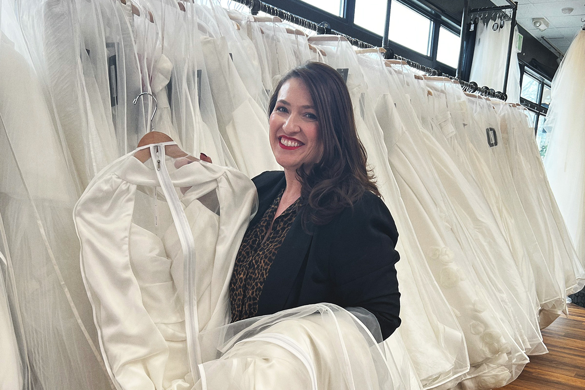 smiling woman holding wedding dress