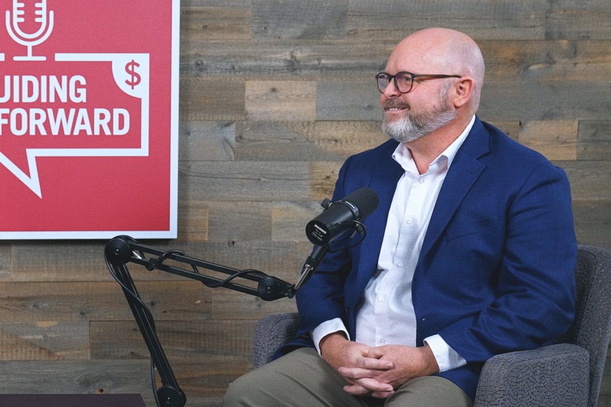 gray bearded man with glasses at the podcast mic