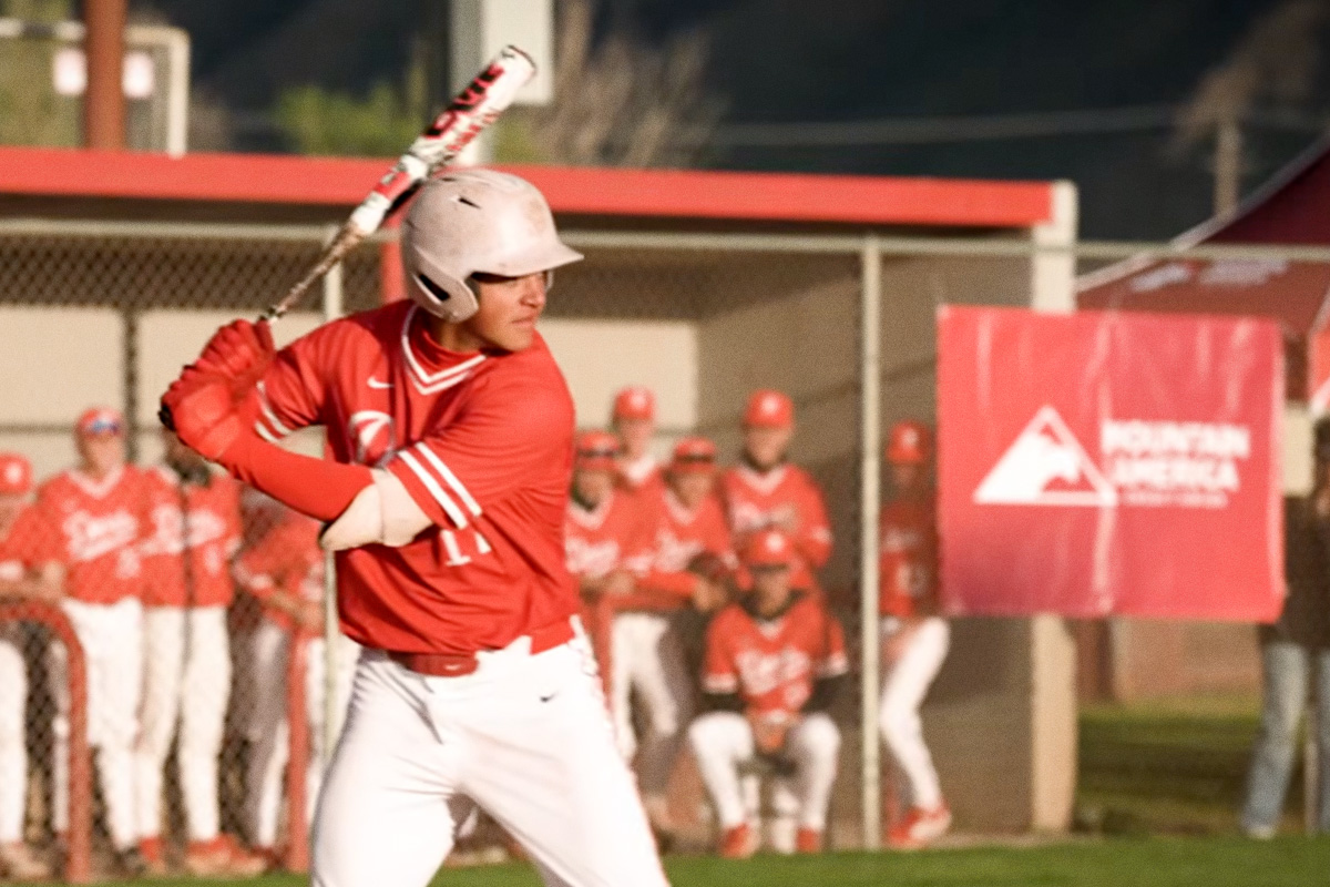 young man at home plate poised to swing bat