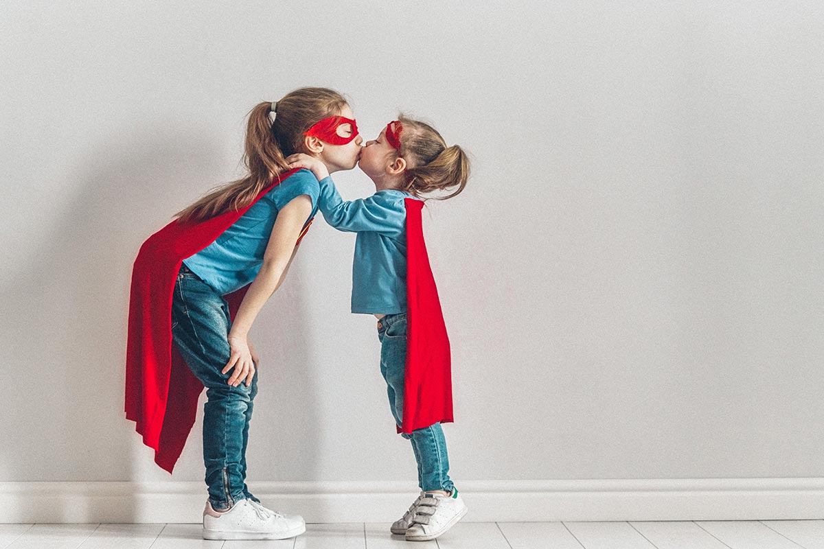 two young sisters dressed in red capes
