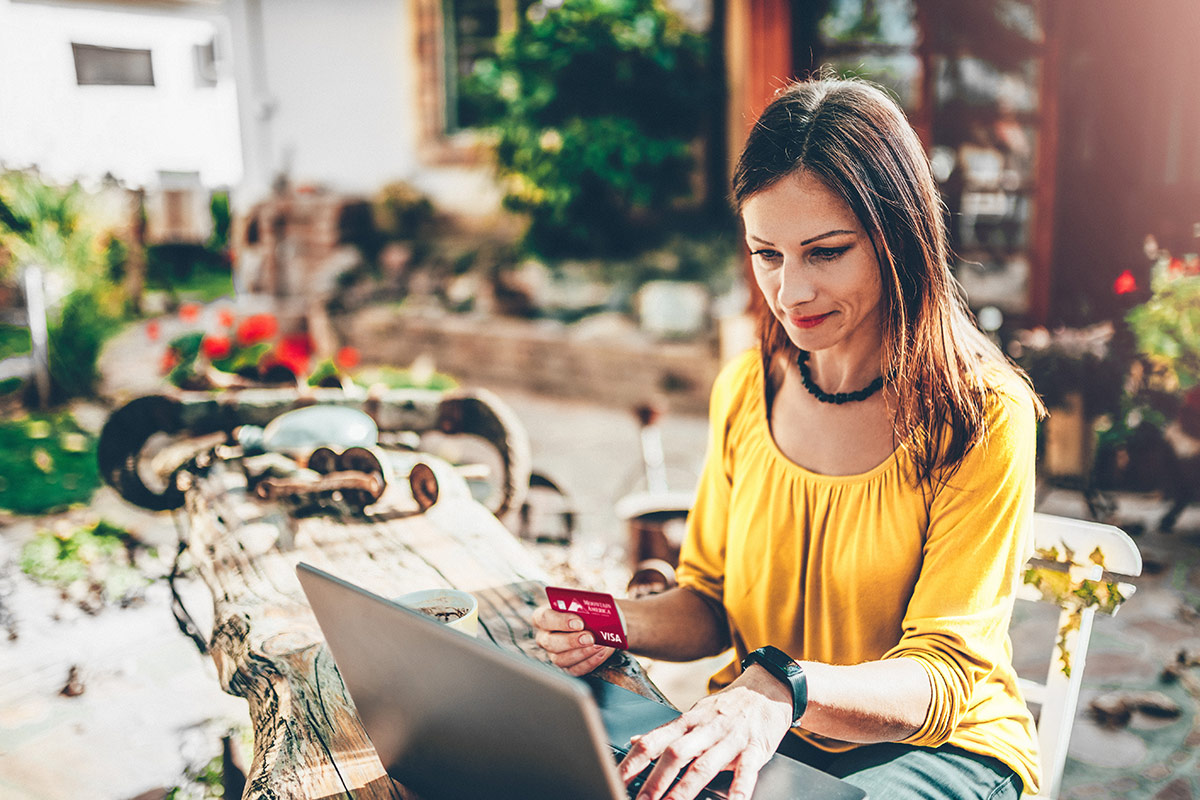 woman making an online purchase on her laptop with a Mountain America Visa card