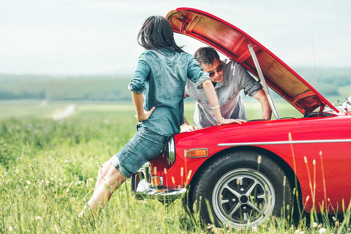 couple working on a red car