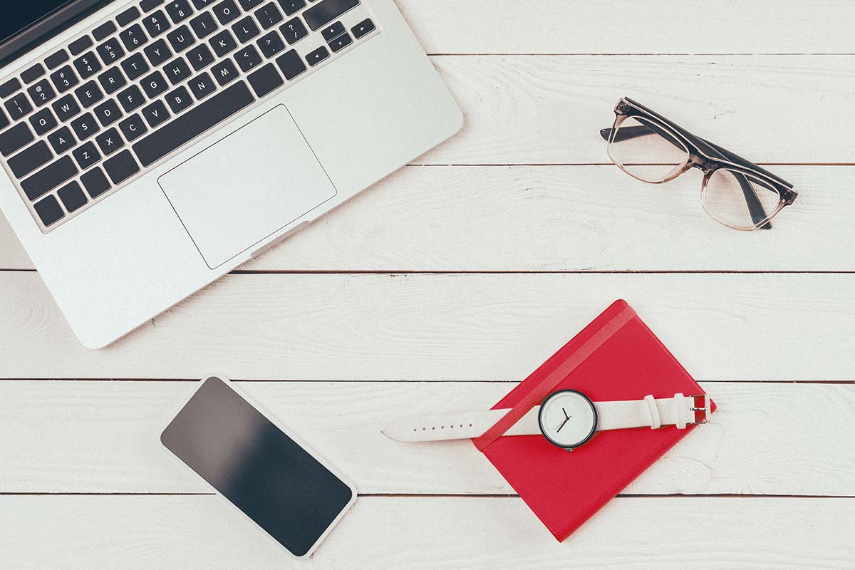 phone, wallet, glasses, watch and laptop on a table