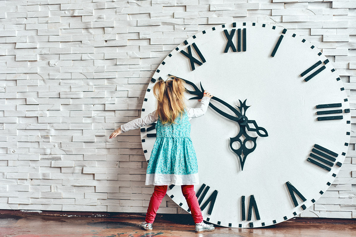 little girl messing with a giant clock