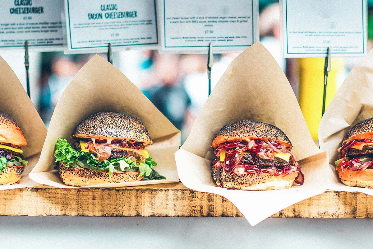 a variety of burgers lined up on a counter