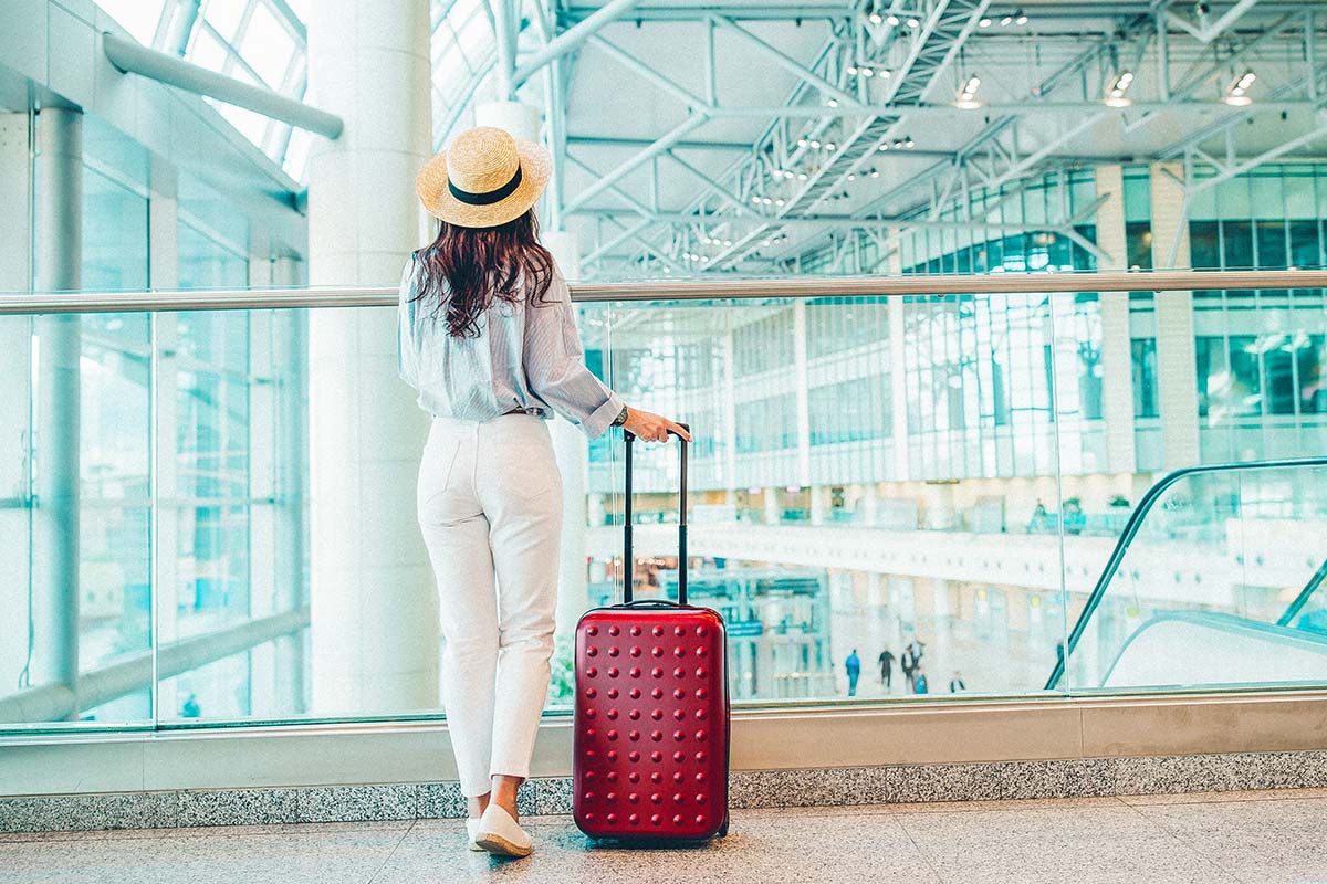 woman with a red suitcase in an airport