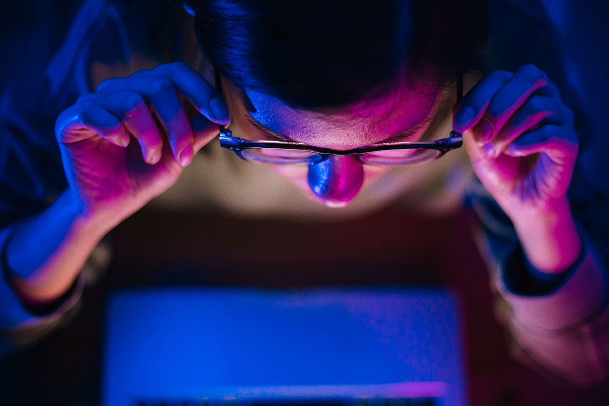 woman looking at laptop in the dark