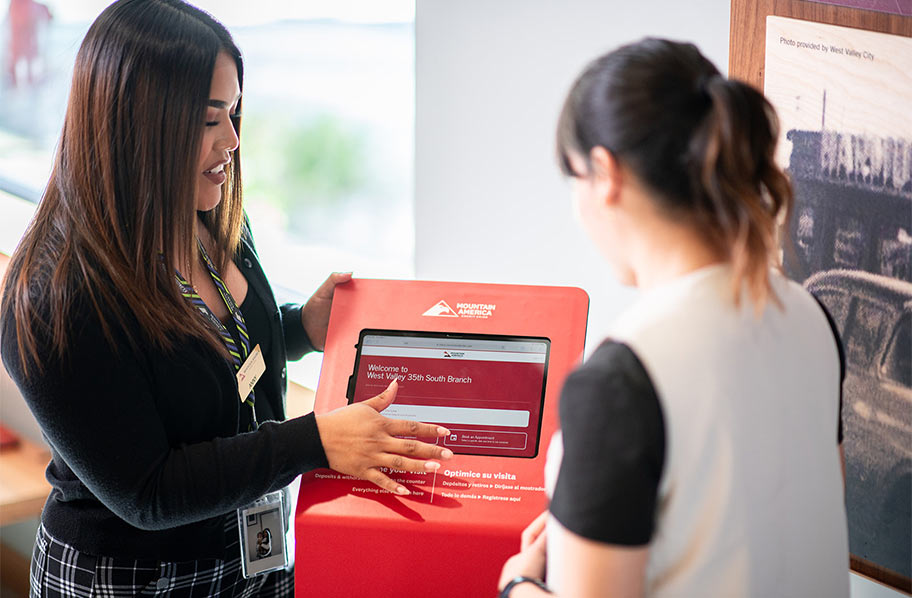 Employee demonstrating how to use kiosk