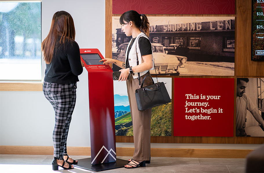 Employee demonstrating how to use kiosk