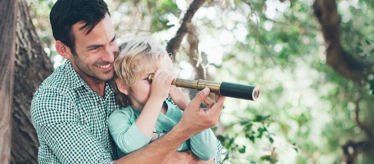 Father and son - son looking through a telescope