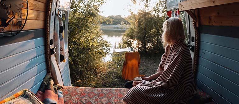 woman sitting in her van looking out the back