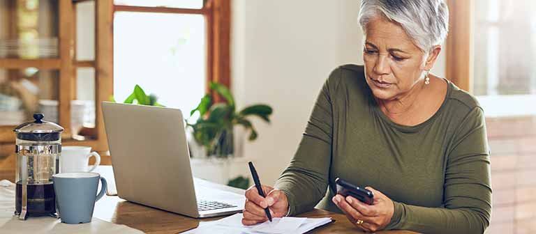 Woman doing calculations on computer