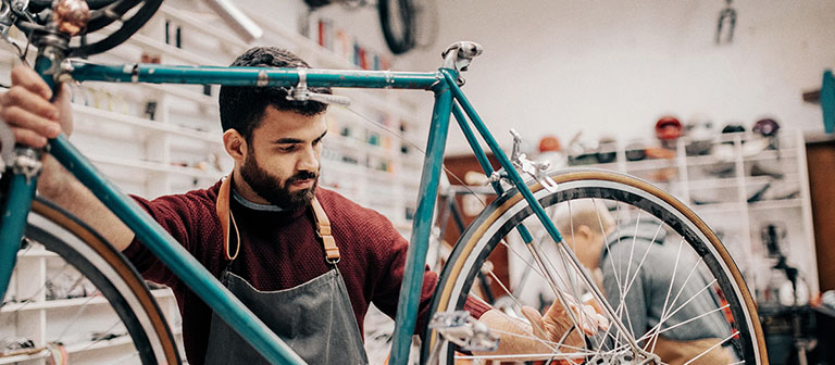 man working on a bike in his shop