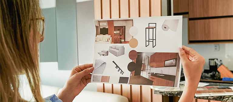 woman holding up a mood board of kitchen designs