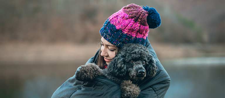 young woman holding a poodle