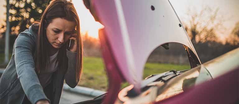 Woman working on broken car