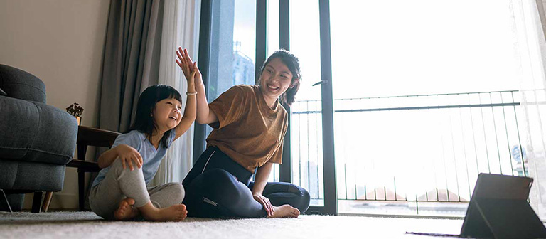 mother and daughter sitting on living room floor