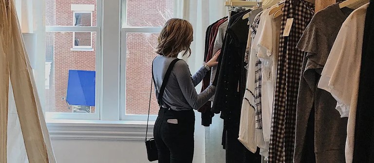 woman looking at a pair of pants at a store